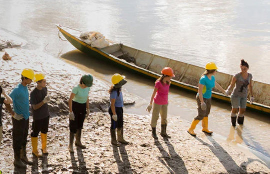 幾位現場工程師沿著河邊用一艘舊船