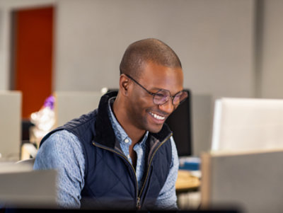 A person smiling and working at their desk