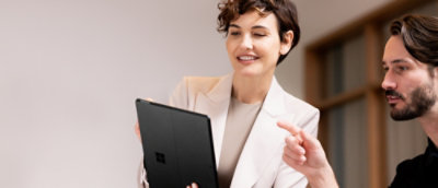 Two people reviewing content on a Microsoft Surface device.