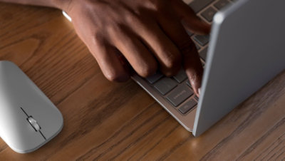 Hands typing on a laptop