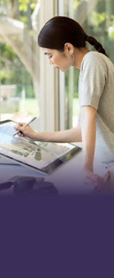 テーブルに寄りかかって大型タッチスクリーン モニターでペンを使用している人