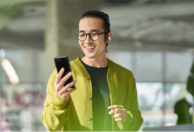 イヤホンをして携帯電話を見ている人