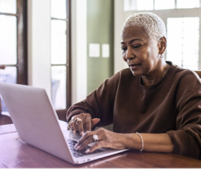 デスクでノート PC を操作している人 