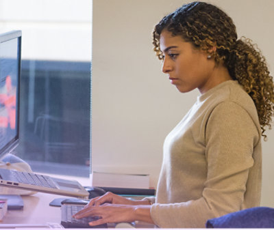 デスクに座ってキーボードで入力している人 