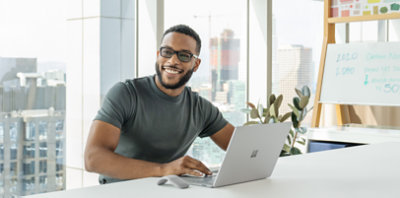 A person smiling and using a laptop