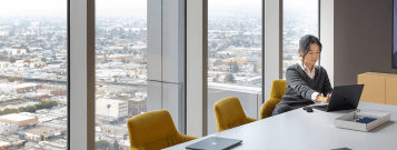 会議室内でノート PC で作業している人