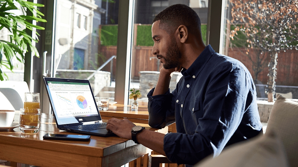 Een persoon die een Excel-blad bekijkt op een laptop in een restaurant
