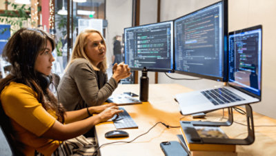 デスクで一緒に作業している 2 人の人