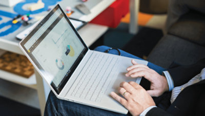 Azure のデータが表示されているノート PC のキーボードから入力している両手