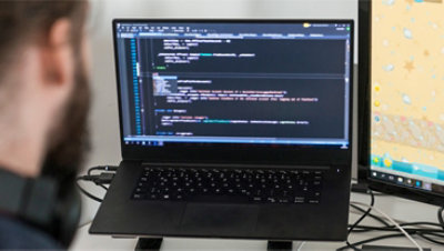 Eine Person, die Code auf ihrem Laptop anzeigt.