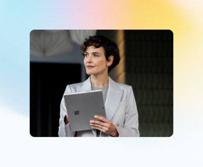 Person i en lysfarget blazer som holder et Microsoft Surface-nettbrett og ser til siden.