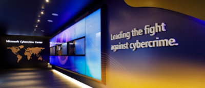 A large screen with a blue and yellow background displaying the text Leading the fight against cybercrime.