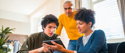 A group of people looking at a tablet.