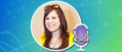 A woman smiling with sunglasses on her head.