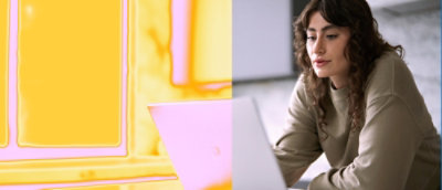 一位女士坐在桌前，桌上有一台膝上型電腦，背景為黃色和粉紅色。