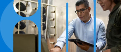 看著機器的兩個人，其中一個人拿著平板電腦