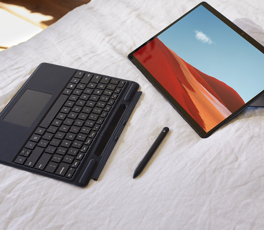 Un Surface Pro X avec un stylet et un clavier.