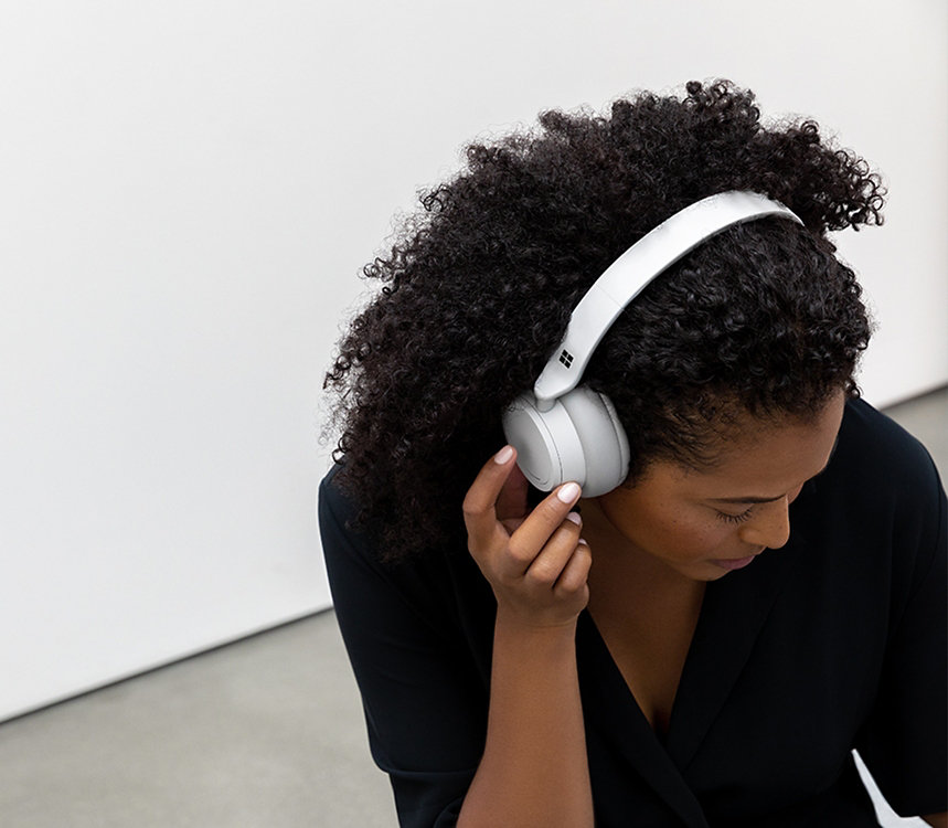 Une personne écoute de la musique avec des écouteurs Surface Headphones.