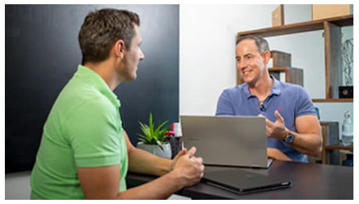 Zwei Männer sitzen sich gegenüber und unterhalten sich.