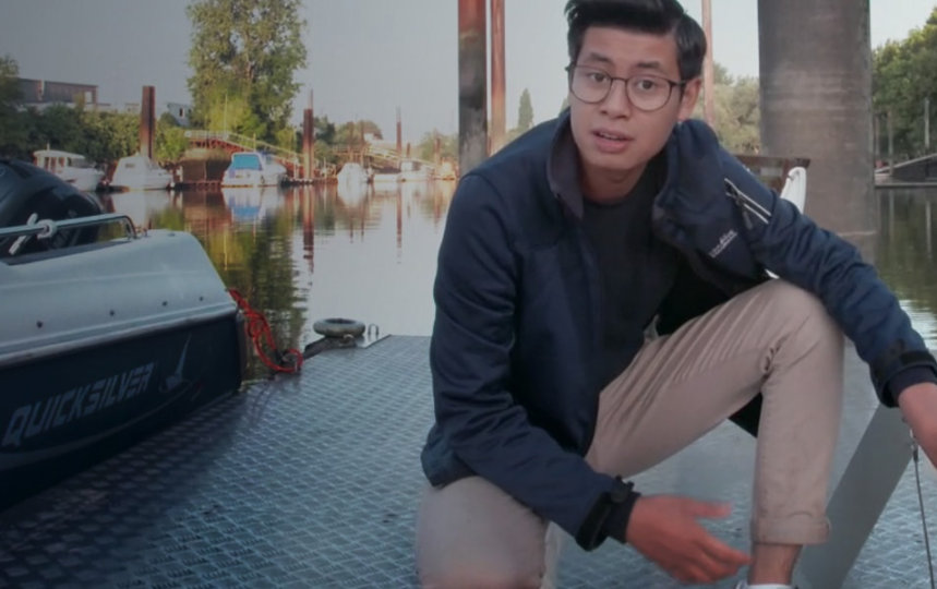 Auftragshacker Philipp Kalweit kniet auf einem Steg und schaut fragend in die Kamera