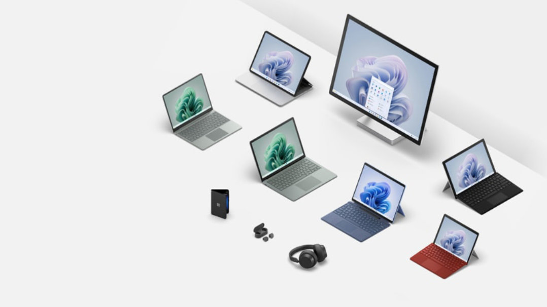 白い背景に配置された Microsoft Surface ラップトップ、タブレット、およびアクセサリのコレクション。