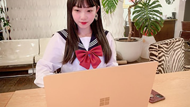 Surface ラップトップを使用している女子高生