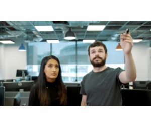 Two Microsoft employees looking one of them pointing at a whiteboard