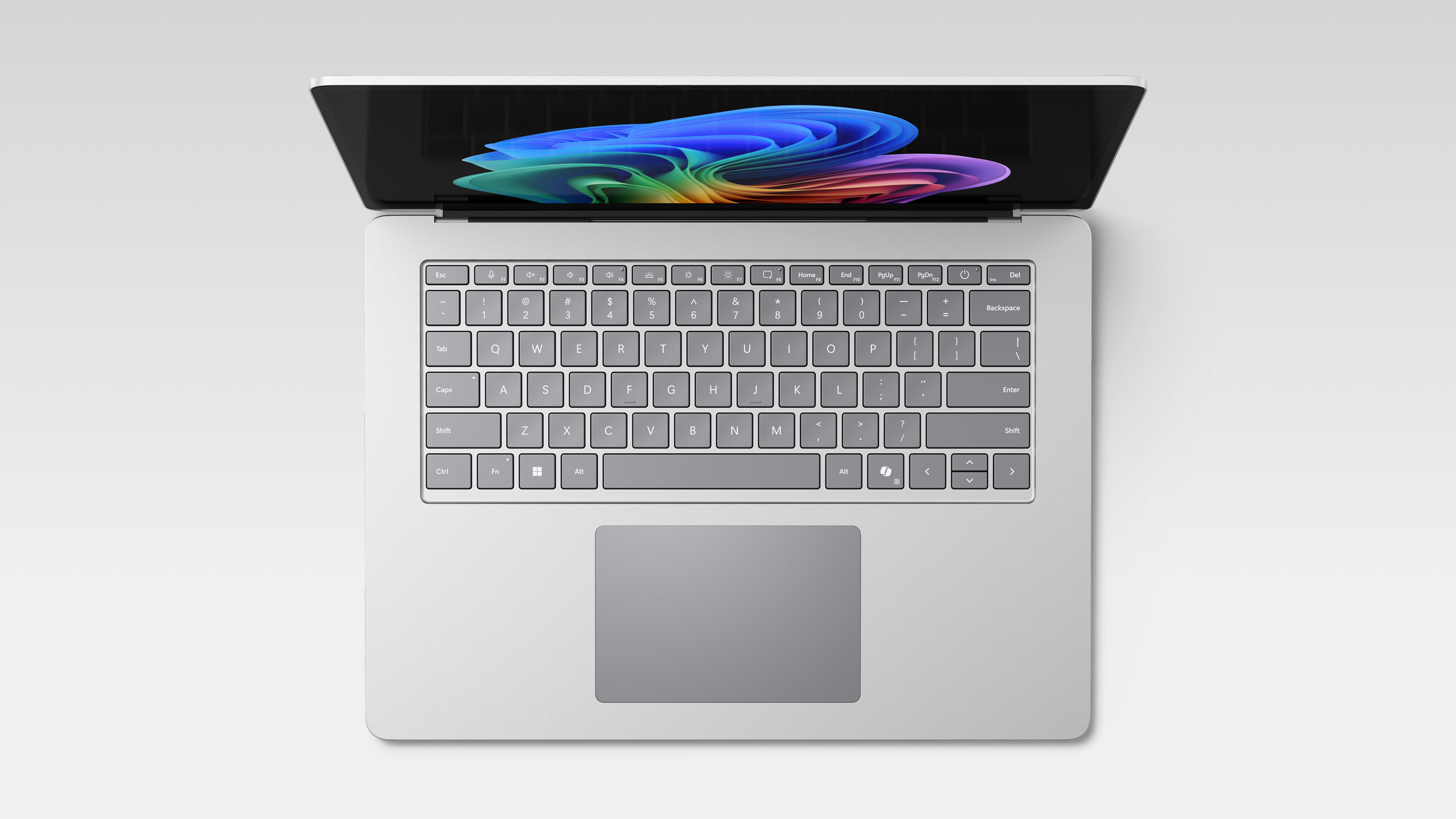 Un ordinateur portable Windows chrome ouvert vu d'en haut avec l'image de fleur arc-en-ciel à l'écran, un clavier complet et un grand pavé tactile.