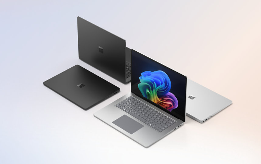 Quatre ordinateurs portables Surface Laptop pour les entreprises, deux noirs et deux platine, dont un ouvert qui affiche l'image de la fleur arc-en-ciel.