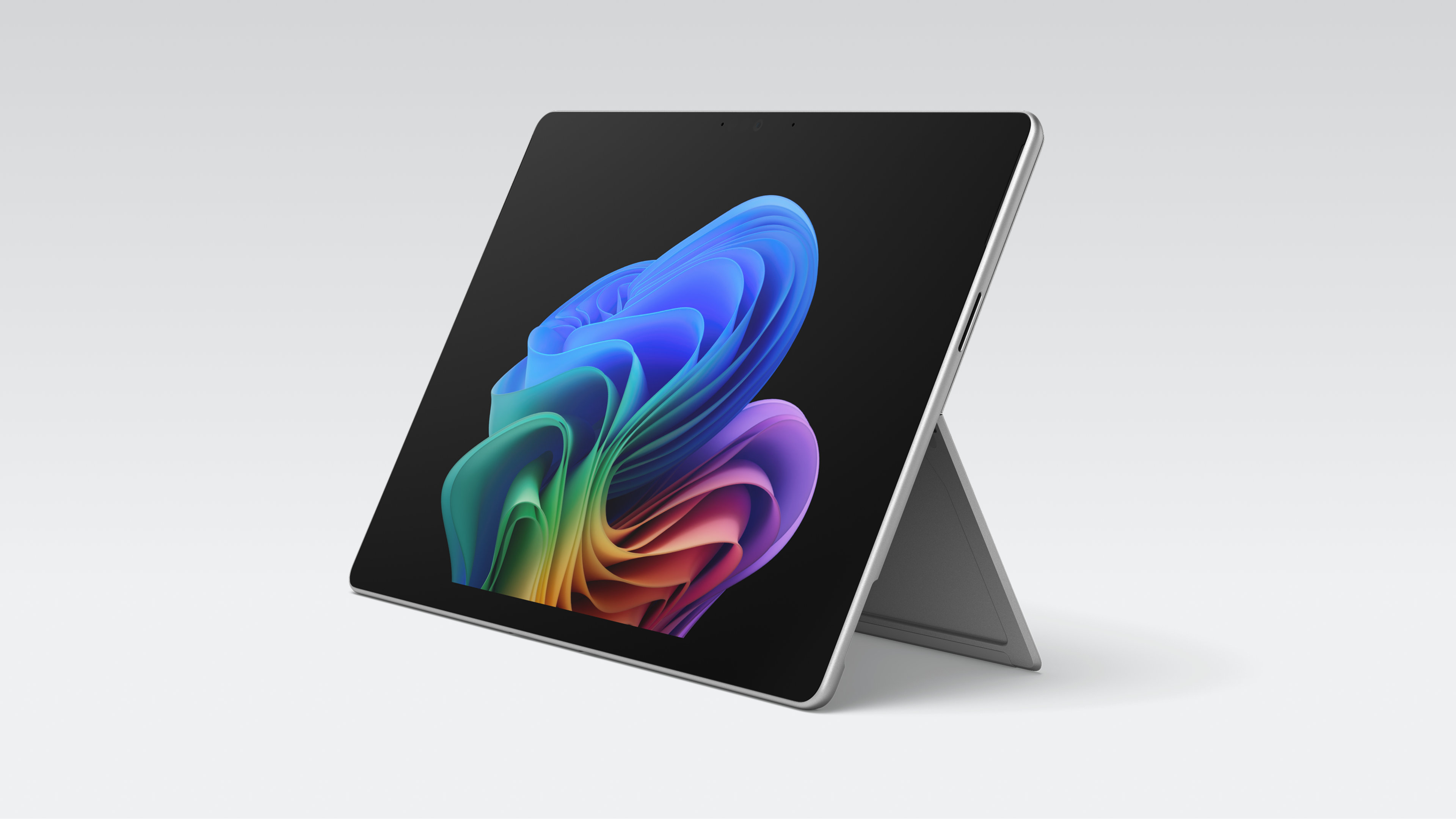 Un ordinateur portable Windows ouvert avec écran tactile antireflet, sans clavier, affichant l'image de la fleur arc-en-ciel sur un fond gris.