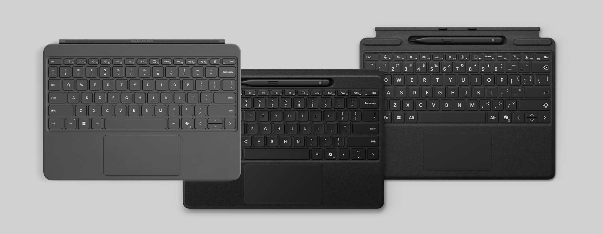 Three Windows Surface devices, one with a grey cover and two with black covers each with a stylus.