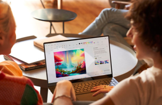 Kaks inimest istub sülearvuti ees avatud rakendusega Paint