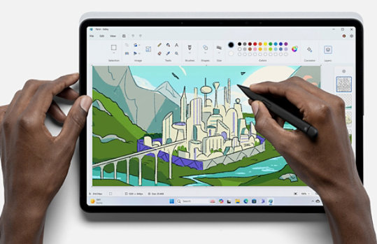 Person holding a pen using the Paint app to create an image