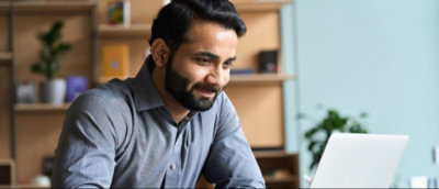 A person with a beard working on laptop.