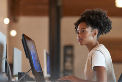 Person, die an einem Laptop in einem modernen Büro arbeitet.