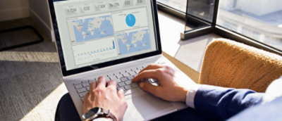Person analyzing data charts on a laptop screen.