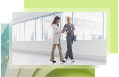 Une femme en blouse blanche parlant à un médecin.