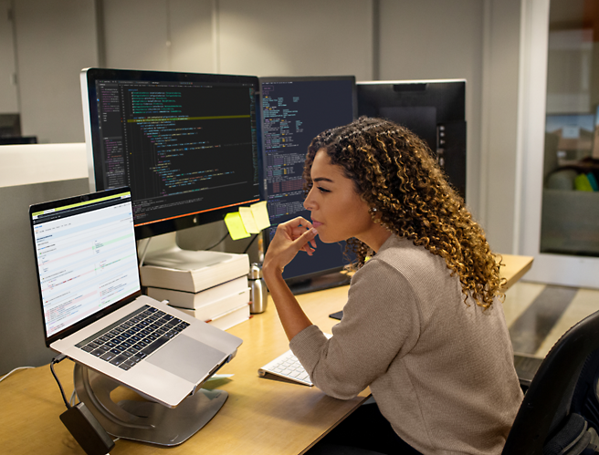 Masada oturan ve bilgisayar ekranına bakan bir kadın