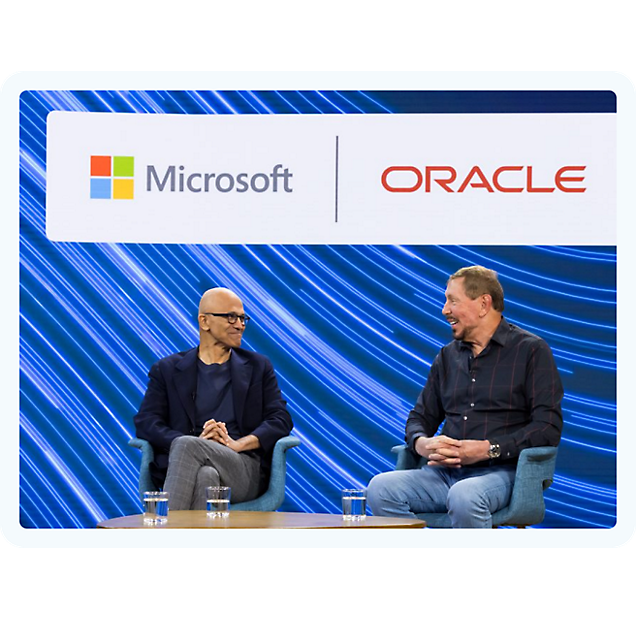 Dwóch mężczyzn siedzących na krzesłach rozmawiających o firmach Microsoft i Oracle.