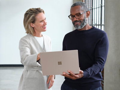 Two coworkers, a man and a woman, looking at a laptop together 