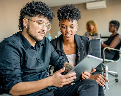 Deux personnes qui regardent une tablette