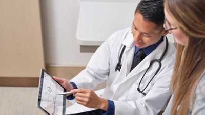 Un médecin qui semble montrer à un patient des données sur une tablette