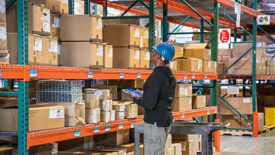 Une personne dans un entrepôt qui semble compter les quantités en stock