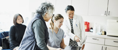 A group of women looking at a laptop.