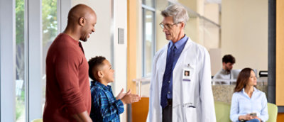 A group of people talking to a boy in a hospital.