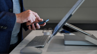 A person using a phone and a computer