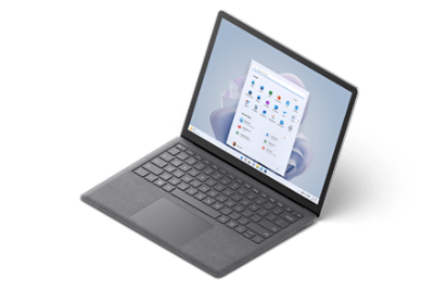 Surface Laptop 5 en version 13,5 pouces et en Alcantara couleur Platine : vue de 3/4 en mode scène avec l’écran Démarrer de Windows 11.