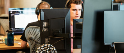 데스크톱에서 작업하는 헤드폰을 쓴 두 사람