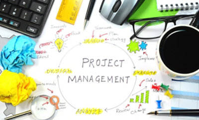 סביבת עבודה מבולגנת עם תרשים זרימה של ניהול פרויקטים, ניירות מקומטים, כוסות, סרגל, עט, עכבר, מקלדת