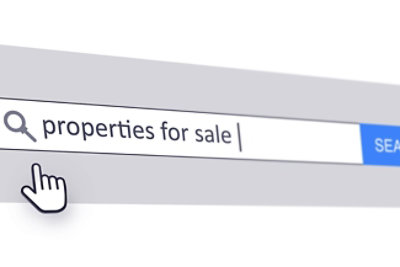 Na ekranu računara se vidi traka za pretragu sa natpisom „nekretnine na prodaju“ i simbol kursora koji lebdi iznad.